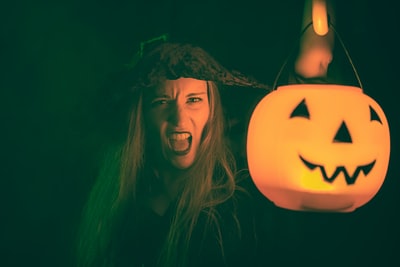 With a jack o lanterns dark-haired woman
